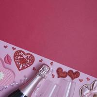 Top view hearts, glasses, champagne, flowers on a pink-red background with copy space valentines day date or party concept photo