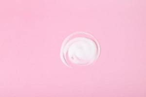 Smear of cosmetic or healing cream on pink surface photo