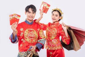 Men and women carry paper bags to go shopping with red envelope photo