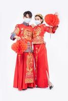 Men and women wearing qipao and wearing face masks Stand with honeycomb lamp photo