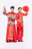 Man and woman wear Cheongsam suit celebrate chinese new year with red lamp and firecracker together photo