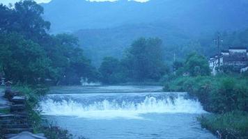 The beautiful countryside view with the waterfall flowing in the mountains after the rainy day photo