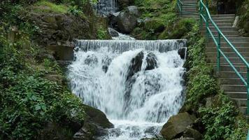 la hermosa vista al campo con la cascada que fluye en las montañas después del día lluvioso foto