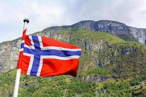 La bandera nacional de Noruega en el cielo azul de viento áspero. foto