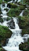 The beautiful countryside view with the waterfall flowing in the mountains after the rainy day photo