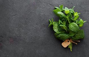Fresh mint leaves herb on stone table. Top view photo
