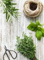 Fresh herbs and twine on wooden background top view photo