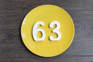 The number sixty-three on the yellow plate. photo