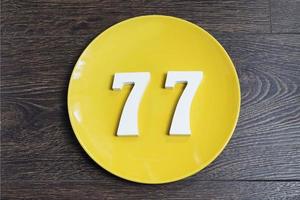 The number seventy-seven on the yellow plate. photo