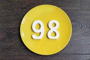 The number ninety-eight on the yellow plate. photo