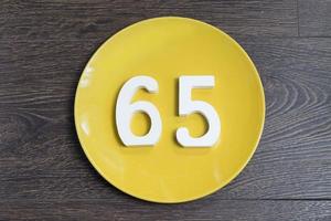 The number sixty-five on the yellow plate. photo