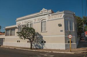 sao manuel, brasil, 14 de octubre de 2017. antigua casa adosada de esquina adornada en una calle vacía con árboles en la acera en sao manuel. un lindo pueblito en el campo del estado de sao paulo. foto