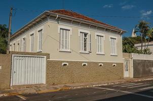 sao manuel, brasil, 14 de octubre de 2017. antigua casa de clase trabajadora con puerta de garaje en una calle vacía en un día soleado en sao manuel. un lindo pueblito en el campo del estado de sao paulo. foto