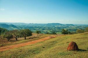 pardinho, brasil - 31 de mayo de 2018. vista de prados y árboles en un valle verde con montículo de tierra de yesca, en un día soleado cerca de pardinho. un pequeño pueblo rural en el campo del estado de sao paulo. foto