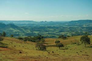pardinho, brasil - 31 de mayo de 2018. vista de prados y árboles en un valle verde con paisaje montañoso, en un día soleado cerca de pardinho. un pequeño pueblo rural en el campo del estado de sao paulo. foto