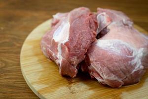 carne de cerdo cruda sobre una tabla para cortar. foto