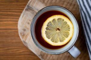 té caliente con limón en una mesa de madera. vista superior. foto