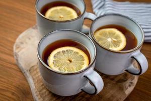 té caliente con limón en una mesa de madera.