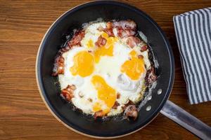Fried egg with bacon in a pan. Top view. photo