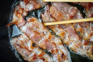 Frying bacon in a preheated pan. Top view. photo