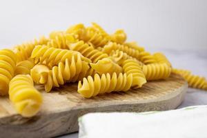 Spiral pasta lying on a wooden board. Raw pasta.