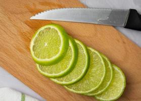 Thinly sliced lime. Preparation of citrus for drinks.