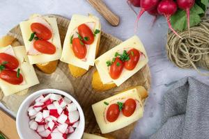 Sandwiches with cheese, tomato and radish. Delicious and healthy breakfast. Top view. photo