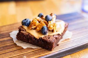 Chocolate brownie with nuts and blueberries on a restaurant table
