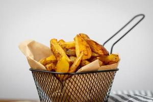 Homemade potato fries in a metal basket. photo