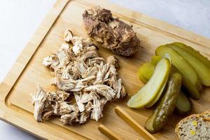 Pulled chicken with bread and pickled cucumber. photo