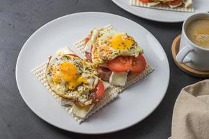 Diet bread sandwiches with egg and juicy tomato on a white plate. View from above. photo