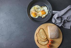 Fried egg with grilled bread on dark background top view space for text