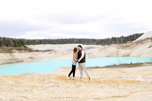 couple kissing against the backdrop of a blue lake - an unusual landscape, copy space photo