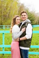 Cheerful couple embracing and posing on the green grass a sunny day photo