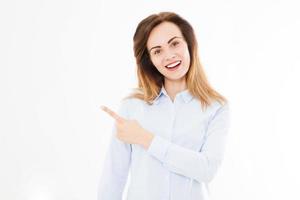 Portrait of smiling attractive, pretty, brunette woman, girl in shirt, pointing. Teen businesswoman. Confident young manager. Copy space. photo