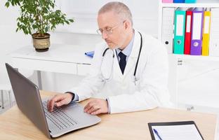 male doctor in medical office works at the computer, medical insurance photo