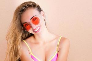 Friendly beautiful summer happy girl in red summer sunglasses posing in isolation photo