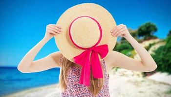 Elegant young lady in summer hat on beach vacation photo