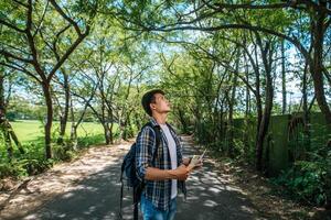 turistas masculinos con una máscara, llevando una mochila en el camino. foto