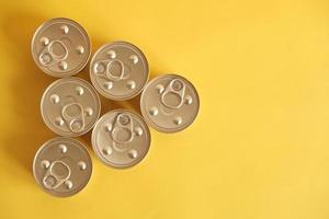 Canned food closed on yellow background photo