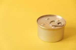 Canned food closed on yellow background photo