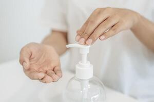 Women wearing white shirts that press the gel to wash hands to clean hands. photo