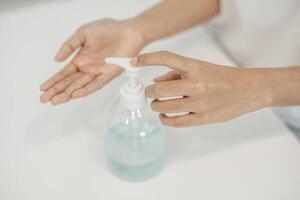 Women wearing white shirts that press the gel to wash hands to clean hands. photo