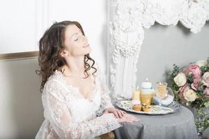 Girl in a white dress sitting at a table photo