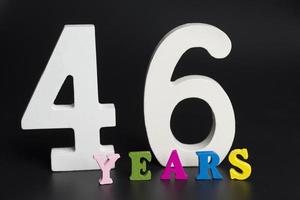 Letters and numbers forty-six years on a black background. photo