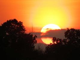 hermosa vista de la puesta de sol roja en la colina foto