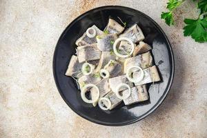rebanada de arenque trozos de pescado con cebolla mariscos comida sana dieta pescetarian foto