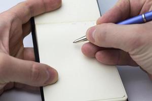 Hand writes in a notebook. photo