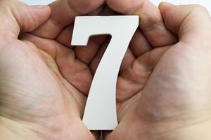 mano sosteniendo el número siete.