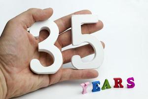 Hand holds a number of thirty-five. photo